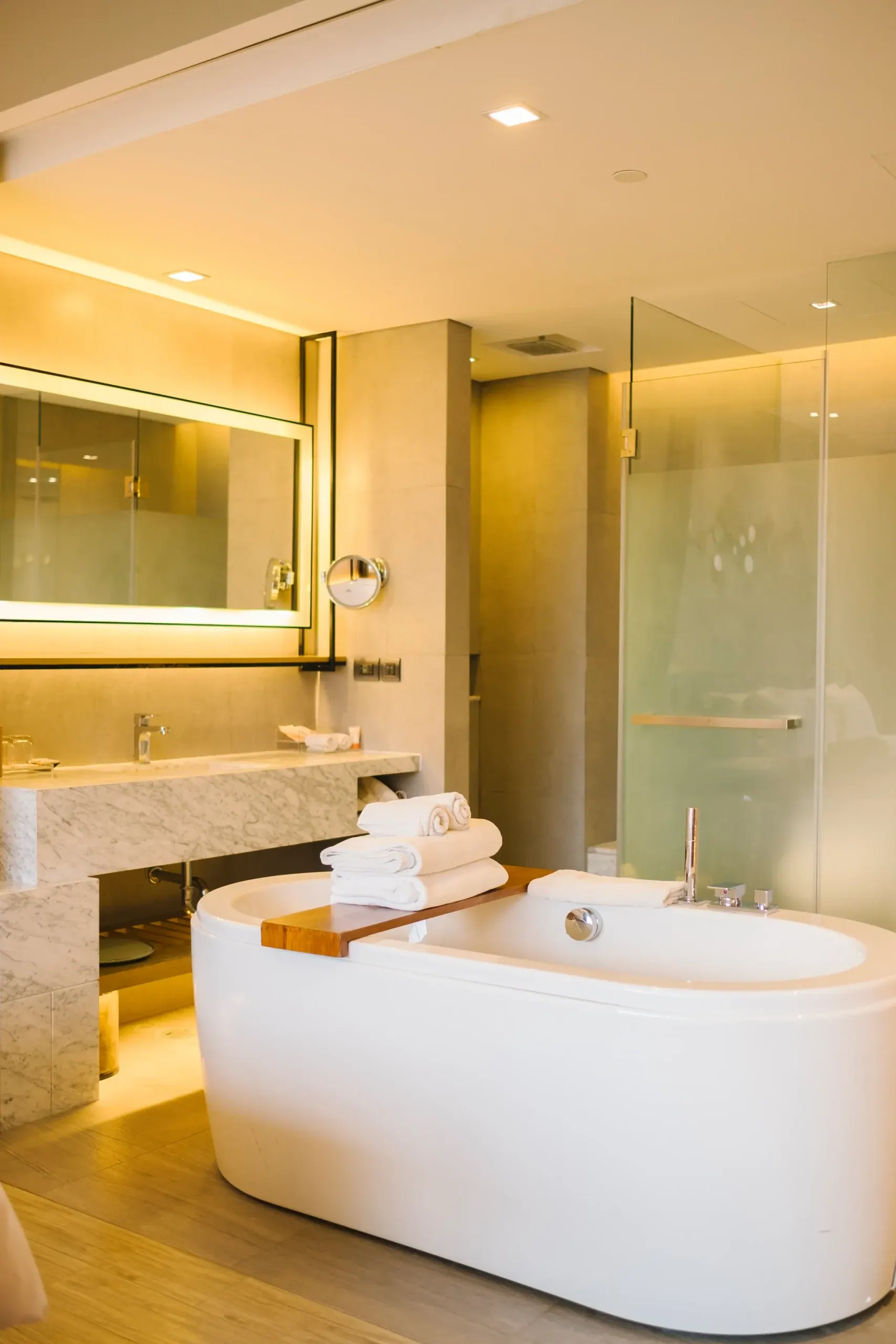 Bathroom with a stone vanity, glass shower panel and soaking tub