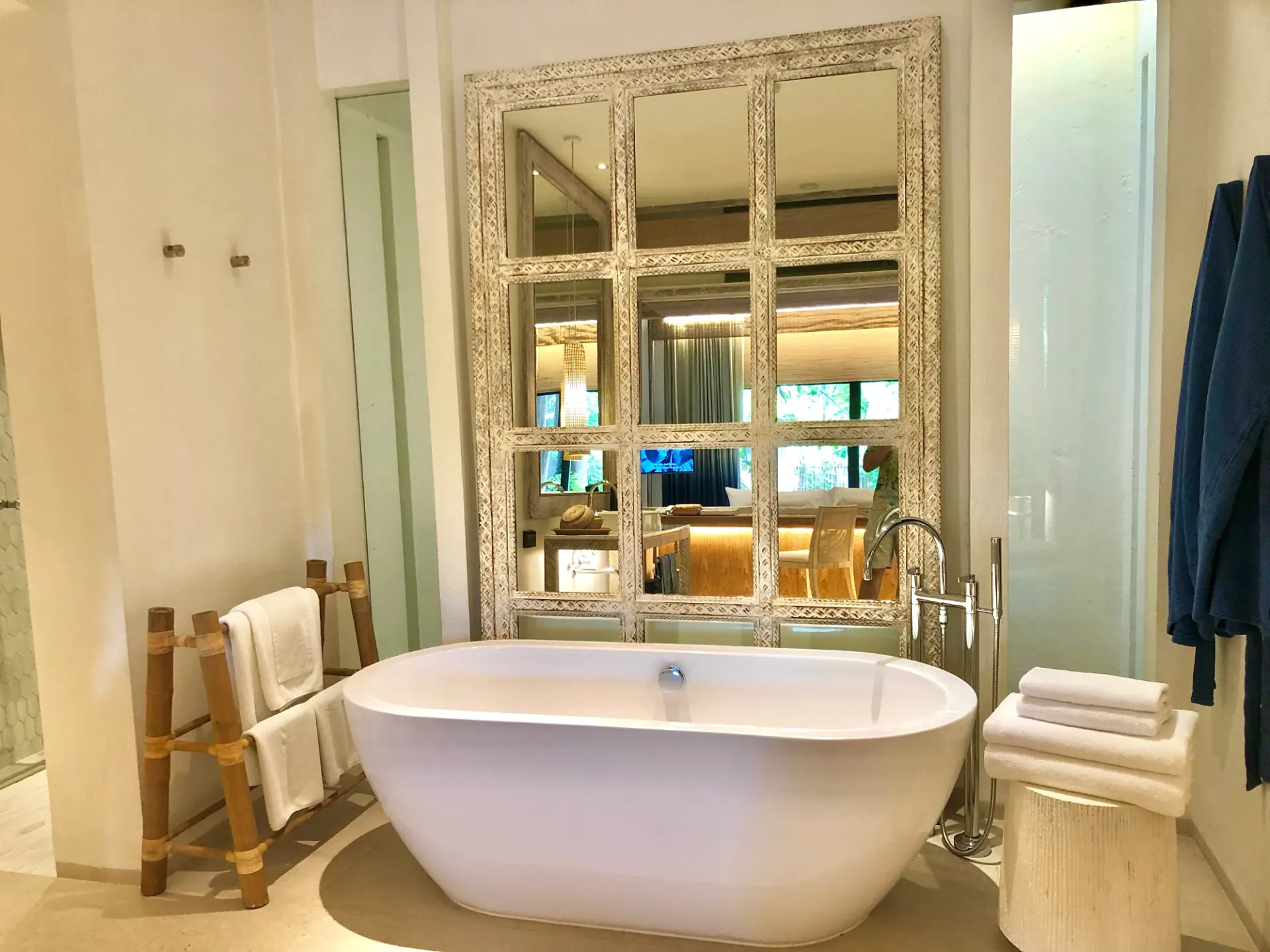 Warm-toned bathroom with a freestanding tub, wood details and white towels