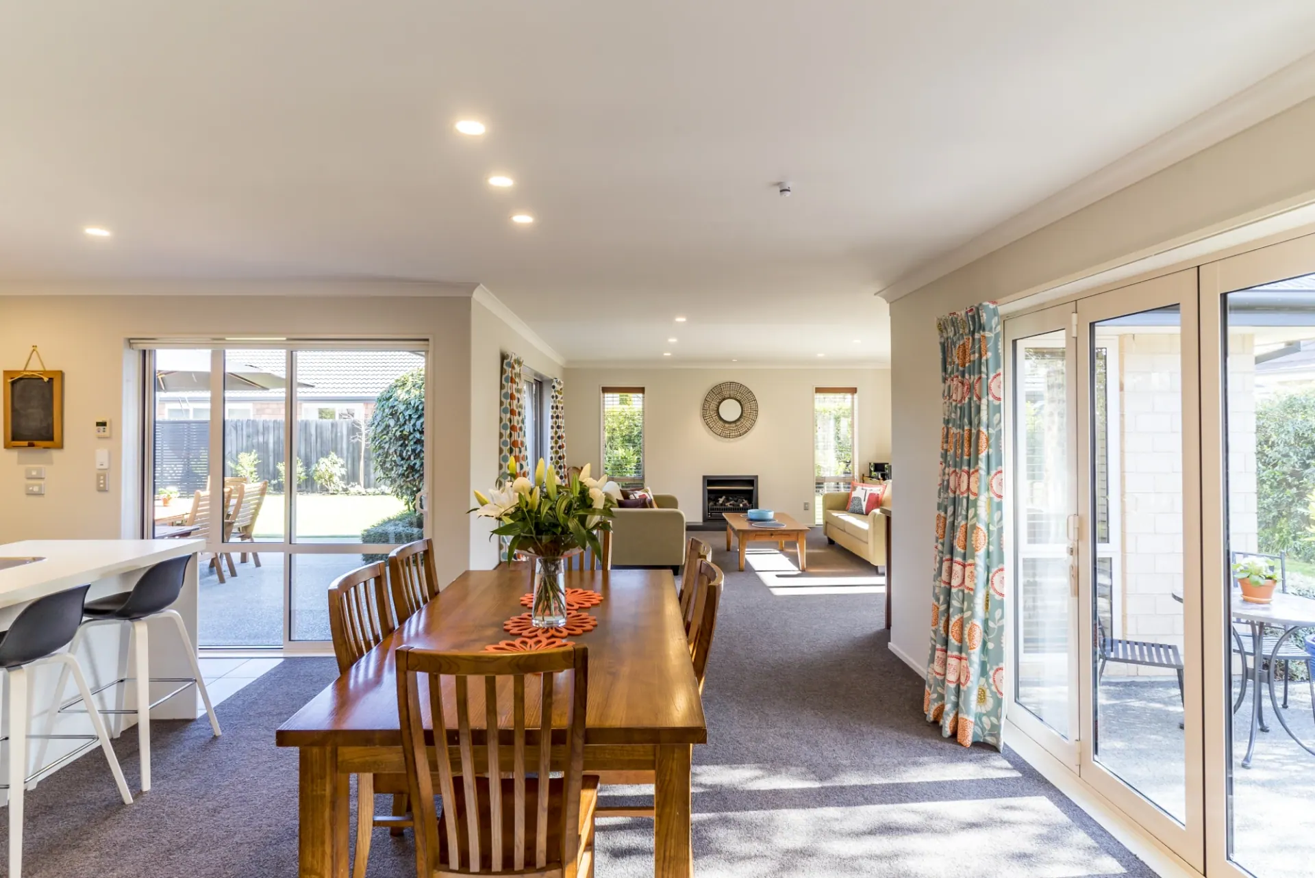 Connected dining and living room with continuous flooring and large glass doors