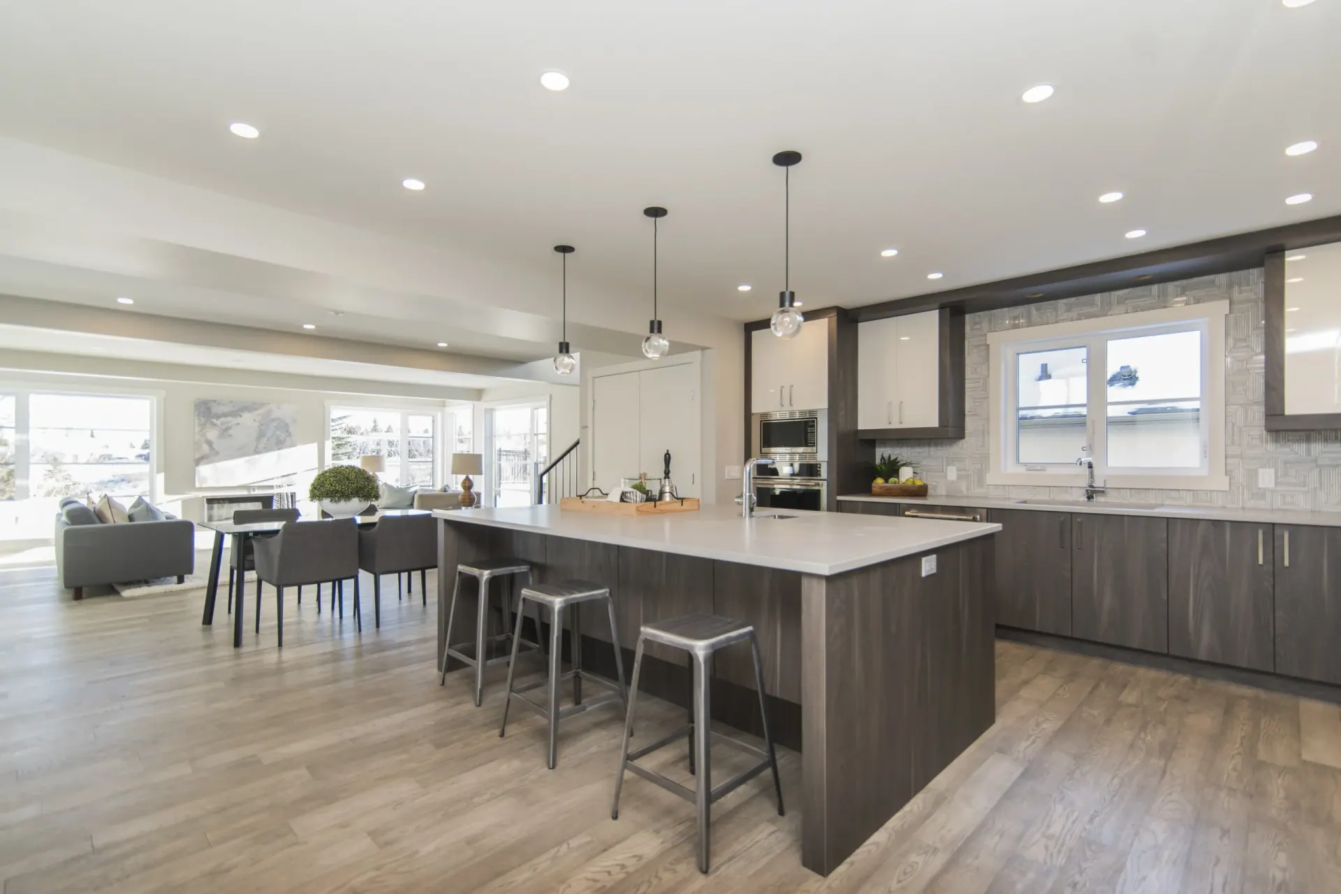 Kitchen with a long island worktop, pendant lights and full-height storage